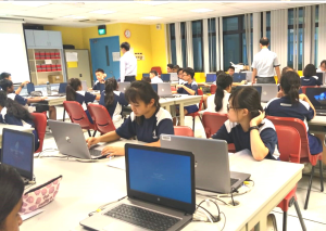 Wide shot of Primary school children using laptops in the computer lab.